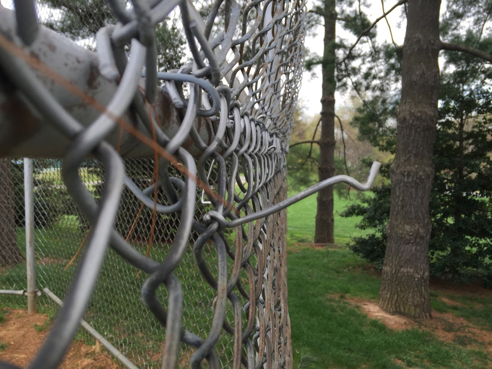 A damaged fence on a baseball field